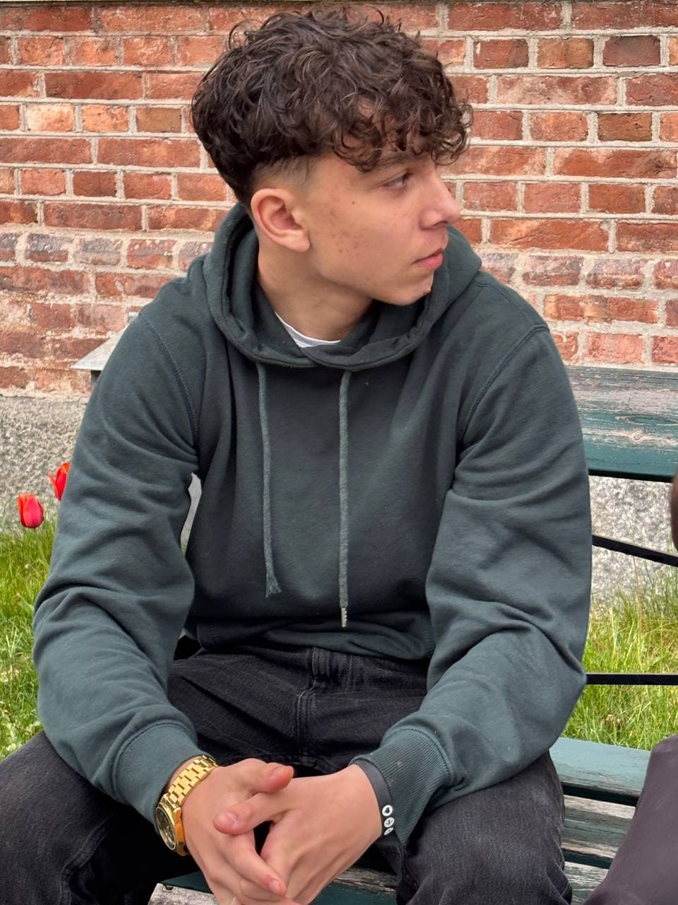 Ezekiel sitting outdoors in front of a brick wall